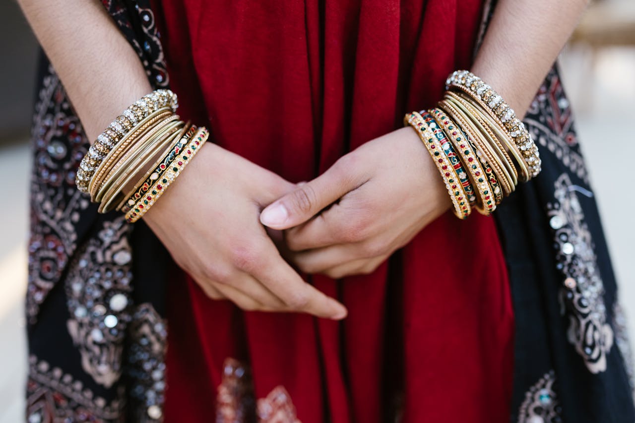 Close-up of a woman's hands adorned with colorful traditional bangles, showcasing cultural attire.